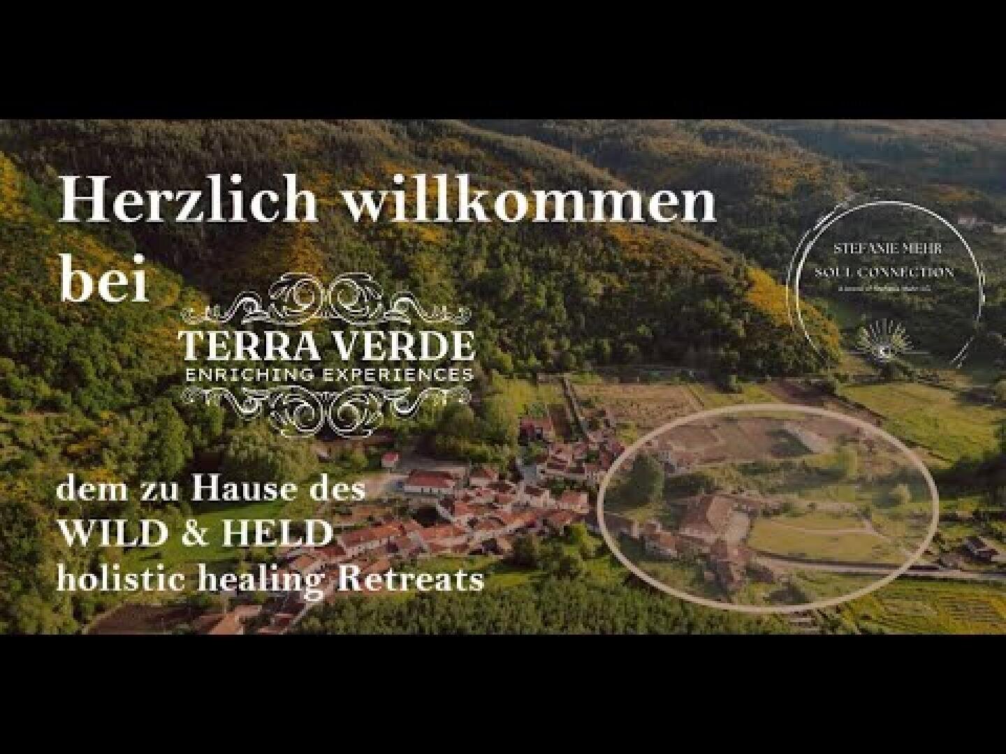 Luftaufnahme einer üppigen, grünen Landschaft mit zwischen Bäumen eingebetteten Gebäuden. Überlagerter deutscher Text begrüßt die Besucher von Terra Verde, der Heimat von Wild & Held Holistic Healing Retreats. Ein kreisförmiger Einschub hebt einen Teil des Grundstücks hervor.