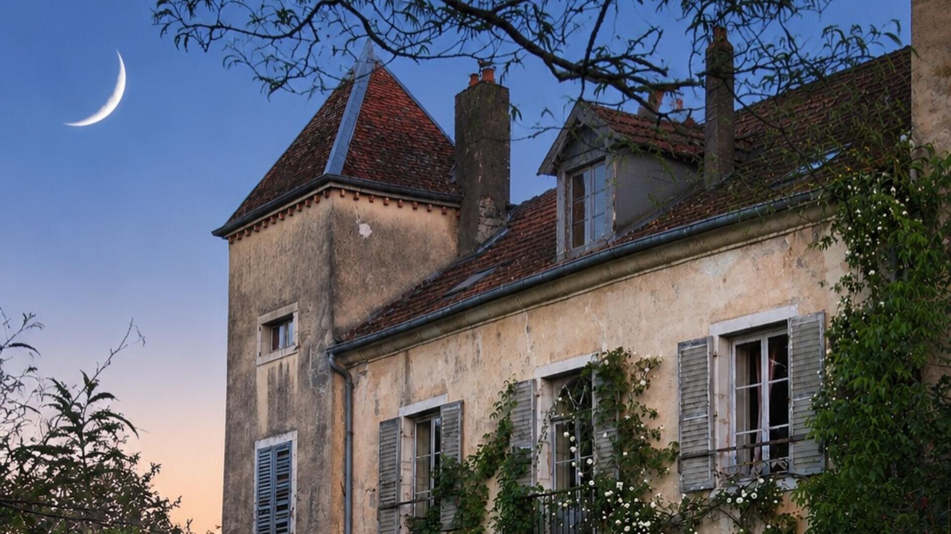In der Abenddämmerung ist ein rustikales Haus mit Fensterläden und Kletterpflanzen zu sehen, während ein Halbmond am klaren Abendhimmel steht und Äste die Szene einrahmen.