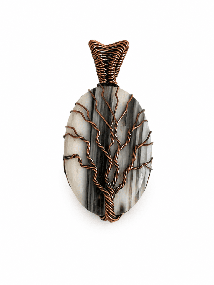 Ovaler Anhänger mit einem schwarz-weißen Stein, umwickelt mit Kupferdraht, der die Form eines Baumes mit über die Oberfläche ausgebreiteten Ästen hat.