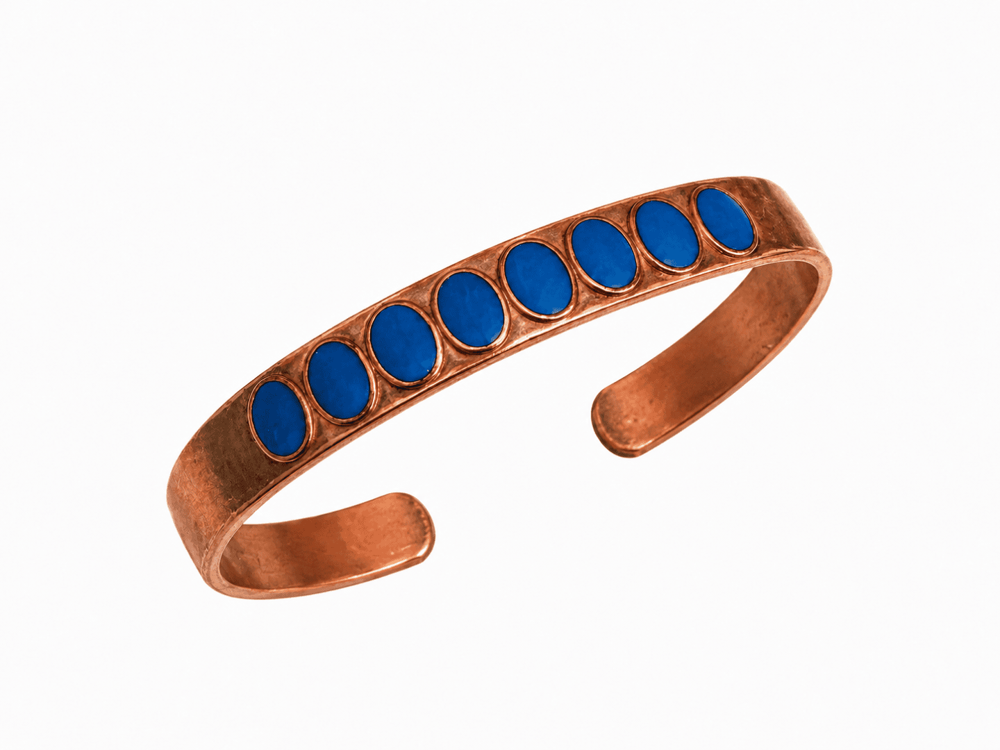 Ein Armreif aus Kupfer mit sieben ovalen blauen Steinen, die oben in einer Reihe angeordnet sind. Der Hintergrund ist schlicht weiß.