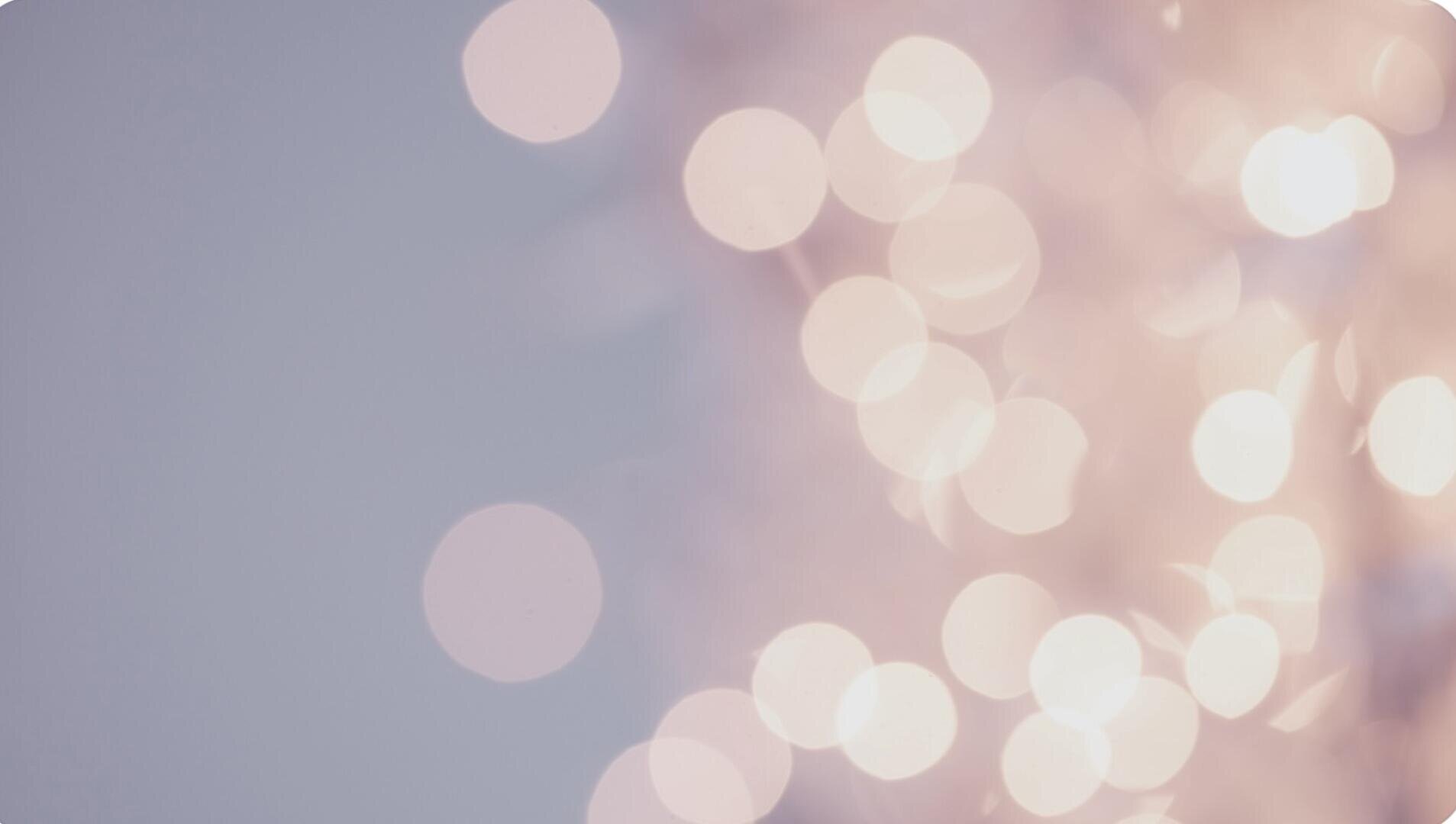 Zartrosa und weiße Bokeh-Lichter erscheinen vor einem blassen Hintergrund verschwommen und erzeugen so einen verträumten, abstrakten Effekt, bei dem keine klaren Formen oder Objekte scharf abgebildet sind.
